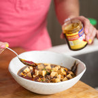 Kenji López-Alt spoons Kari Kari chili crisp onto a bowl of mapo tofu